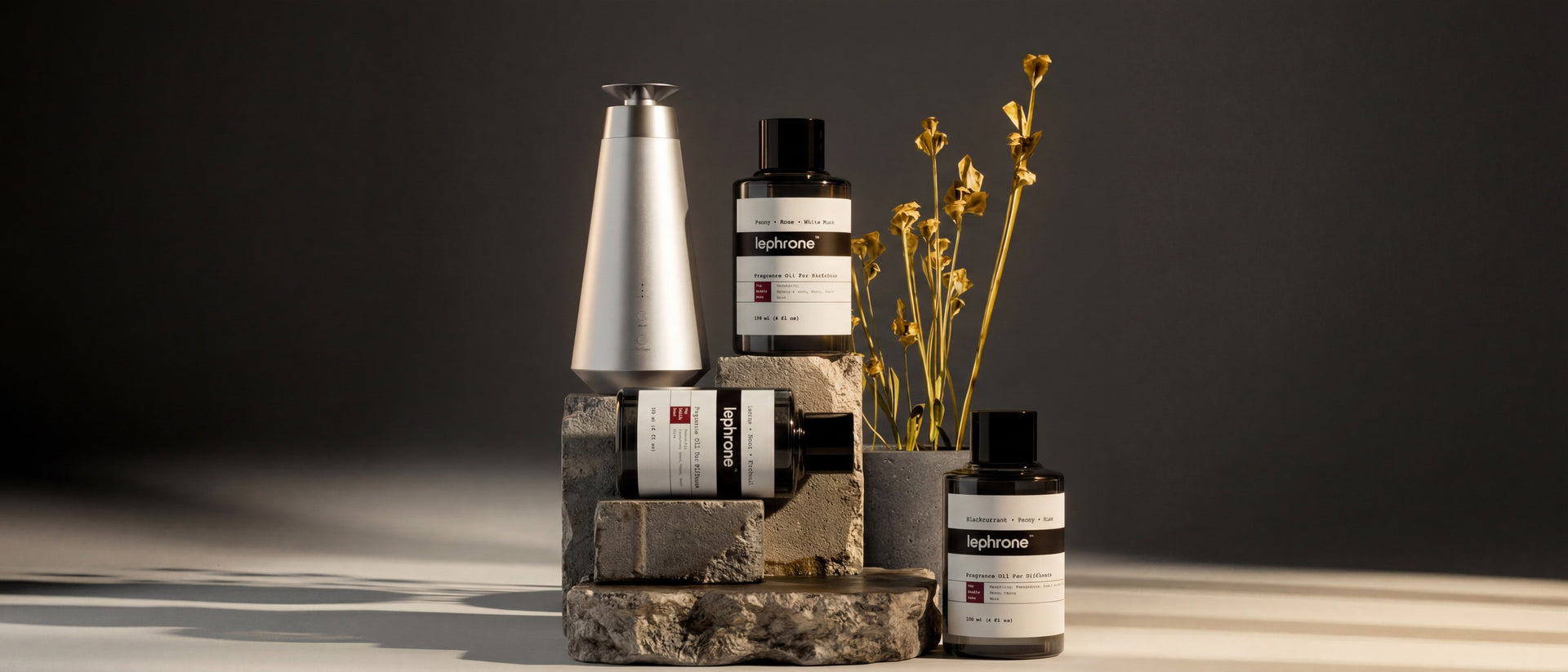 Collection of Lephrone diffuser and oils products on a stone block with a dark background